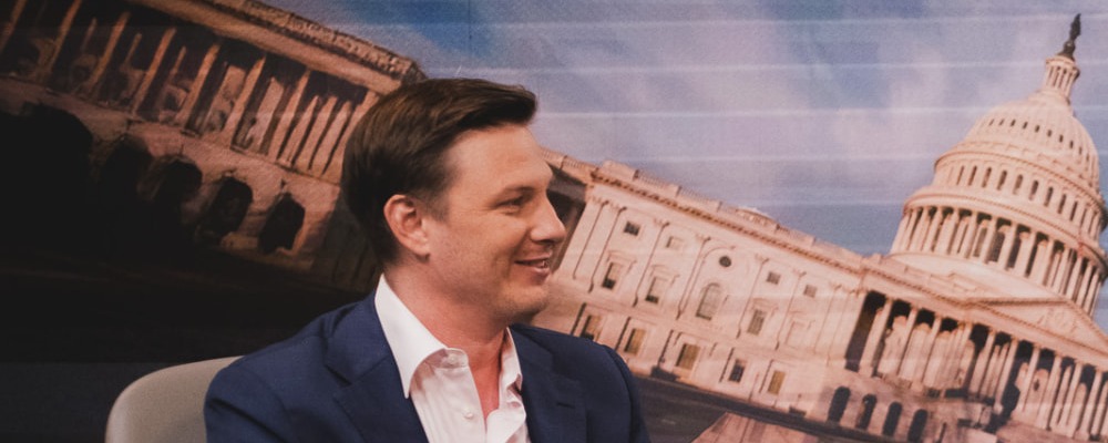 Austin Setzer in conversation with Mark Albert on a Washington television set